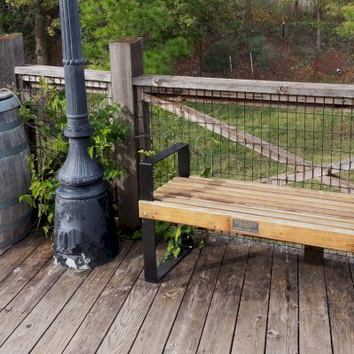 Alameda Wooden Bench (Options: 4 ft, California Redwood, No Cushion, No Engraving, Custom Plaque, Semi-Transparent Stain). Comment: Photo Courtesy of the Oklahoma Zoological Society. Finish is faded somewhat because benches have been out in the weather for nearly 2 years.