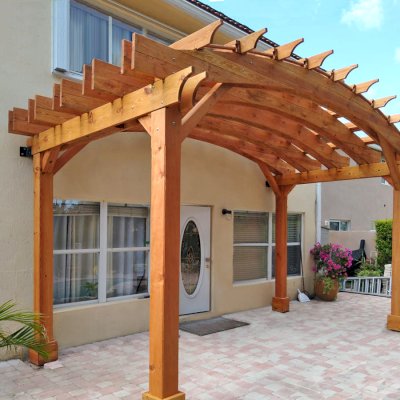 Custom Arched Open Sky Pergolas (Options: Douglas-fir, 10' H Posts, 4-Post Anchor Kit for High-Wind, Transparent Premium Sealant). Shows custom wall anchor customization to attach to home (can be added upon request).