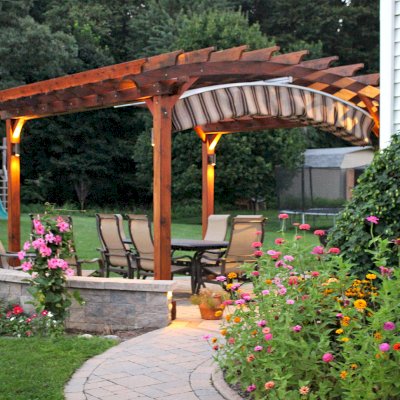 Arched Open Sky Pergolas (Options: 14' L x 14' Arc W, California Redwood, Unattached, Electrical Wiring Trim for 2 Posts, Arched Roof without Lattice Panels, 4-Post Anchor Kit for Concrete, No Ceiling Fan Base, No Privacy Panels, No Curtain Rods, 9' Post Height, Transparent Premium Sealant). 18" Overhang of Arches. Ends of arches with Same Roosevelt End Detail Work as Have the Supports and Slats. Pergola Installed in 2014. Photo Courtesy of J. Martin of Morgantown, Pennsylvania.