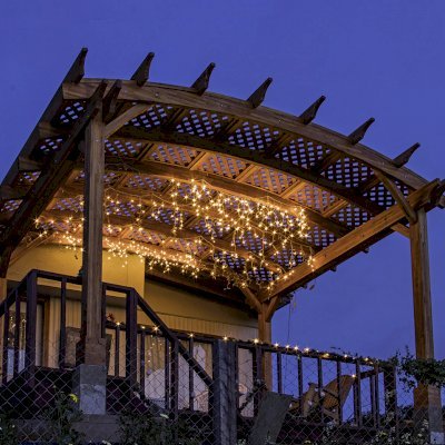 Arched Pergola Kit (Options: 12' L x 16' Arc W, Mosaic Redwood, No Electrical Wiring Trim Kit, 4-Post Anchor Kit for Wood, No Ceiling Fan Bases, No Privacy Panels, No Curtain Rods, 9' Post Height, Transparent Premium Sealant). Free Standing Pergola was altered slightly to place up against house by limiting overhang on house side.