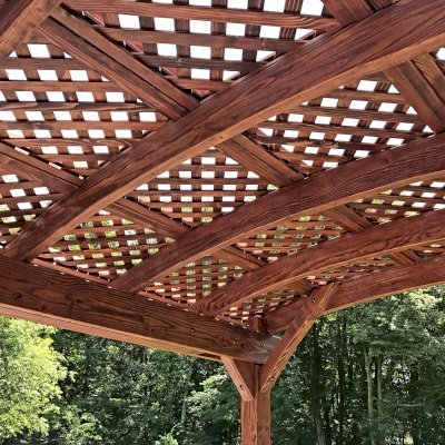 Arched Pergola Kit (Options: 14' L x 10' Arc W, Douglas-fir, No Electrical Wiring Trim Kit, 4-Post Anchor Kit for Concrete, No Ceiling Fan Base, No Privacy Panels, No Curtain Rods, 9' Post Height, Cherry Stain Premium Sealant). Photo Courtesy of D. McAlpine of Holliston, Massachusetts.