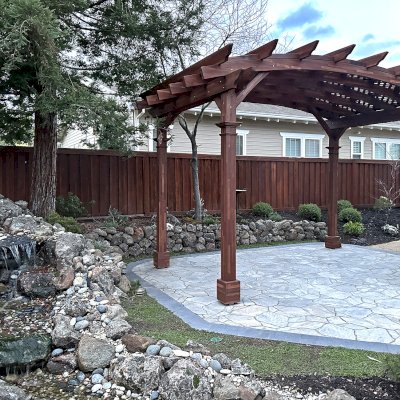 Arched Pergola Kit (Options: 10' L x 16' Arc W, No Privacy Panels, Mosaic Redwood, Horizontal Post Decorative Trims, Viking End Cut Detail, 1 Electrical Wiring Trim, 9.5' H Posts, No Curtain Rod, No Privacy Panel, 4-Post Anchor Kit for High-Wind, Coffee-Stain Premium Sealant). Photo Courtesy of F. Castillo of Livermore, CA.
