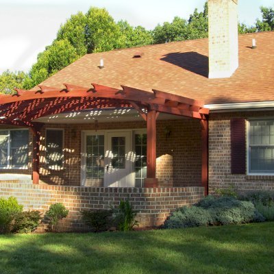 Arched Pergola Kits (Options: 10' L x 22' Arc W, Mature Redwood, No Electrical Wiring Trim, 4-Post Anchor Kit for Stone, No Ceiling Fan Base, No Privacy Panels, No Curtain Rods, 9' Post Height (Front Posts Shorter by Custom Request), Cherry Stain Premium Sealant). Photo Courtesy of Josef M. of Fayetteville, Pennsylvania.