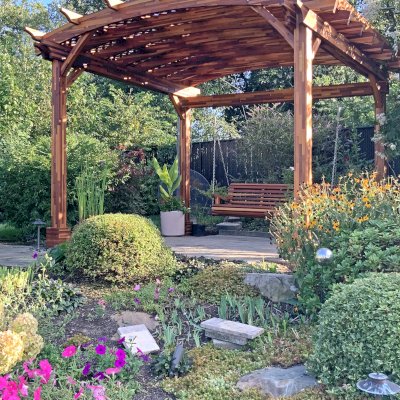 Arched Pergola Kit (Options: 12.5' L x 14' Arc W, Mosaic Redwood, No Electrical Wiring Trim Kit, No Fan Base, No Privacy Panels, Transparent Premium Sealant). Photo Also Shows a XL Bench Swing, Ensenada Style. Photo Courtesy of D. Doty of Bowie, NY.