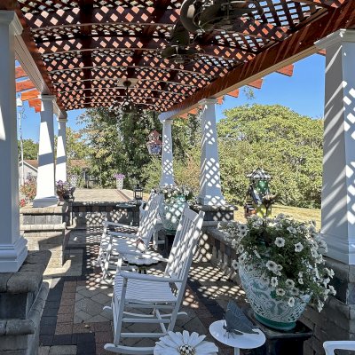 Arched Pergola Kit (Options: 27' L x 11.5' Arc W, Old-Growth Redwood, 1 Electrical Wiring Trim, Post Anchor Kit for Stone, 2 Ceiling Fan Base, No Privacy Panels, No Curtain Rods, 9' Post Height, Posts Surrounded with Fiber Glass Columns, 18" Overhangs Instead of the Standard 12", Transparent Premium Sealant). Photo Taken 9 Years After Installation. Photo Courtesy of E. Jowett of Cambridge, OH.