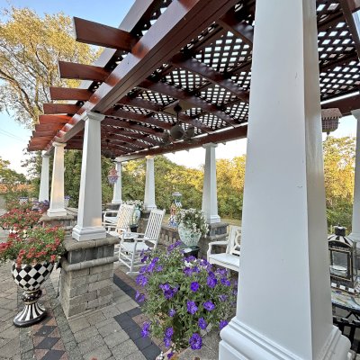 Arched Pergola Kit (Options: 27' L x 11.5' Arc W, Old-Growth Redwood, 1 Electrical Wiring Trim, Post Anchor Kit for Stone, 2 Ceiling Fan Base, No Privacy Panels, No Curtain Rods, 9' Post Height, Posts Surrounded with Fiber Glass Columns, 18" Overhangs Instead of the Standard 12", Transparent Premium Sealant). Photo Taken 9 Years After Installation. Photo Courtesy of E. Jowett of Cambridge, OH.