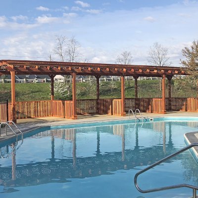 Arched Pergola Kits (Options: 40' L x 14' Arc W, California Redwood, No Electrical Wiring Trim, 10-Post Anchor Kit for Wood, 2 Ceiling Fan Bases, No Curtain Rods, Transparent Premium Sealant). Privacy stalls added by custom request. Photo Courtesy of D. Hatcher of Lewis Center, OH.