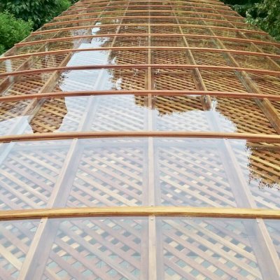Arched Pergola Kit (Options: 74' L x 18.5' Arc W, Mature Redwood, with Rainguard, Electrical Wiring Trim for 1 Post, 10-Post Anchor Kit for Concrete, 2 Ceiling Fan Bases, No Privacy Panels, No Curtain Rods, with Transparent Rain Guard, 9' Post Height, Transparent Premium Sealant). Photo Courtesy of H. Mitchell of The Plains, VA.