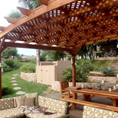 Arched Pergola Kits (Options: 16' L x 20' Arc W, California Redwood, No Electrical Wiring Trim, 4-Post Anchor Kit for Stone, No Ceiling Fan Base, No Privacy Panel, No curtain Rods, 9' Post Height, Transparent Premium Sealant). 12' Patio Table w/Benches & Ruth Chairs Also Shown. Photo courtesy of Mr. M. Tomacelli of Fallbrook, CA.