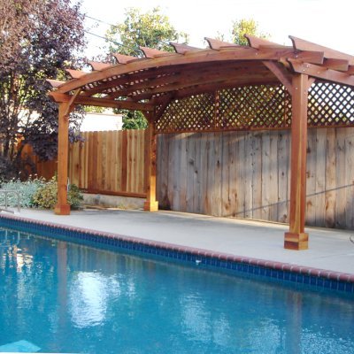 Arched Pergola Kits (Options: 10' L x 20' Arc W, California Redwood, No Electrical Wiring Trim, 4-Post Anchor Kit for Stone, No Ceiling Fan Base, 1 Privacy Panel, No Curtains Rods, 9' Post Height, Transparent Premium Sealant). 