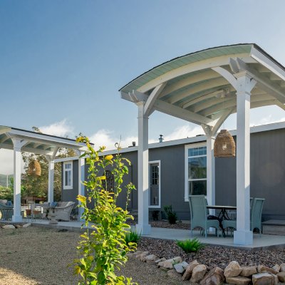  Arched Thick Timber Pavilion (Options: 12' L x 12' Arc W, Douglas-fir, 1 Electrical Wiring Trim, 4-Post Anchor Kit for Concrete, 1 Ceiling Fan Base, No Privacy Panel, No Curtain Rods, 12 ft H, Horizontal Decorative Trims on Posts, Custom Paint). Photo Courtesy of Siino Ventures of Kikrland, Washington.