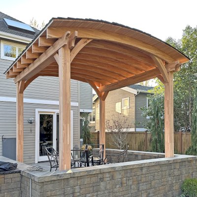  Arched Thick Timber Pavilion (Options: 14' L x 14' Arc W, Mosaic Douglas-fir, 2 Electrical Wiring Trims, 4-Post Anchor Kit for High-Wind, 1 Ceiling Fan Base, 11' H Posts, No Privacy Panel, No Curtain Rods, 12 ft H, No Decorative Trims on Posts, Unfinished). Photo Courtesy of K. Bachman-Ellis of Bellevue, WA.