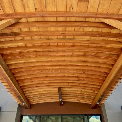 Custom  Arched Thick Timber Pavilion (Options: 10' L x 12' Arc W, Douglas-fir, 2-Post Anchor Kit for Concrete, No Ceiling Fan Base, 11'-5" H Posts, No Privacy Panel, No Curtain Rods, No Decorative Trims on Posts, Transparent Premium Sealant). Pavilion attached as an extension of an existing 5' L roof. Photo Courtesy of R. Cole of Fairfield, CA.