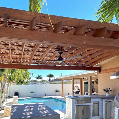 Attached Arched Pergola Kits (Options: 15' L x 20' W, Douglas-fir, Vertical Post Decorative Trims, 1 Electrical Wiring Trim, Rafters at 18" and Slats at 18", Widthwise Roof Support Timbers, 2-Post Anchor Kit for Concrete, 1 Ceiling Fan Base, No Privacy Panels, No Curtain Rods, 9' Post Height, Coffee-Stain Premium Sealant). Photo Courtesy of N. Lizazo of Sunrise, FL.