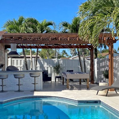 Attached Arched Pergola Kits (Options: 15' L x 20' W, Douglas-fir, Vertical Post Decorative Trims, 1 Electrical Wiring Trim, Rafters at 18" and Slats at 18", Widthwise Roof Support Timbers, 2-Post Anchor Kit for Concrete, 1 Ceiling Fan Base, No Privacy Panels, No Curtain Rods, 9' Post Height, Coffee-Stain Premium Sealant). Photo Courtesy of N. Lizazo of Sunrise, FL.