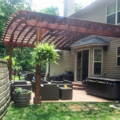 Attached Arched Pergola Kits (Options: 20' L x 26' W, Douglas-fir, No Electrical Wiring Trim, Rafters at 18" and Slats at 18", Widthwise Roof Support Timbers, 2-Post Anchor Kit for Concrete, Ceiling Fan Base, No Privacy Panels, No Curtain Rods, 11' Post Height, Coffee-Stain Premium Sealant). Photo Courtesy of Susanne Stephens of Eureka, Missouri.