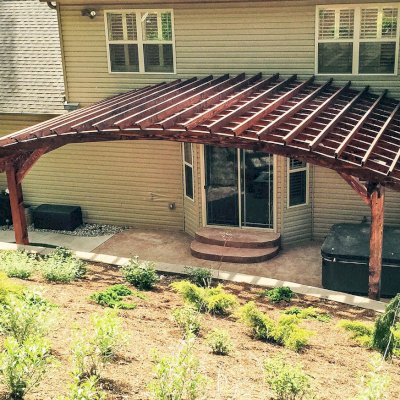 Attached Arched Pergola Kits (Options: 20' L x 26' W, Douglas-fir, No Electrical Wiring Trim, Rafters at 18" and Slats at 18", Widthwise Roof Support Timbers, 2-Post Anchor Kit for Concrete, Ceiling Fan Base, No Privacy Panels, No Curtain Rods, 11' Post Height, Coffee-Stain Premium Sealant). Photo Courtesy of Susanne Stephens of Eureka, Missouri.