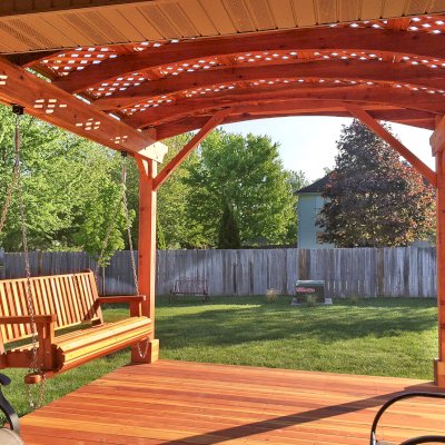 Attached Arched Pergola Kits (Options: 10' x 10', California Redwood, No Electrical Wiring Trim, with Lattice Panels, 2-Post Anchor Kit for Concrete, No Ceiling Fan Base, No Privacy Options, No Curtain Rods, 9ft H, Transparent Premium Sealant) with Deck and Bench Swing by Custom Request. Photo Courtesy of Telory of A. of Springfield, MO.. 