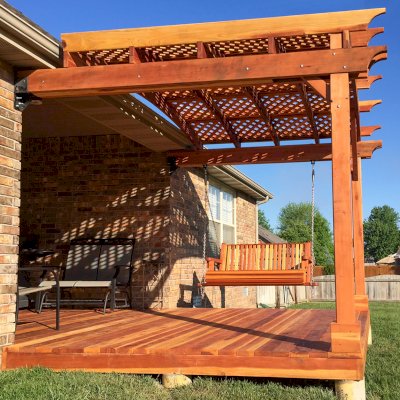 Attached Arched Pergola Kits (Options: 10' x 10', California Redwood, No Electrical Wiring Trim, with Lattice Panels, 2-Post Anchor Kit for Concrete, No Ceiling Fan Base, No Privacy Options, No Curtain Rods, 9ft H, Transparent Premium Sealant) with Deck and Bench Swing by Custom Request. Photo Courtesy of Telory of A. of Springfield, MO.. 