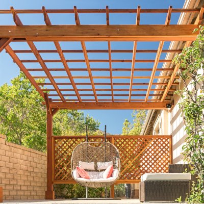 Attached Garden Perglola (Options: 12'-6" x 16', California Redwood, Open Roof with Slats at 18", Rafters at 18", Attached to the Wall by Rafter Side, 2-Post Anchor Kit for Concrete, 1 Lattice Privacy Panel, No Ceiling Fan Base, Transparent Premium Sealant). Photo Courtesy of S. Abbasi of Newbury Park, CA.