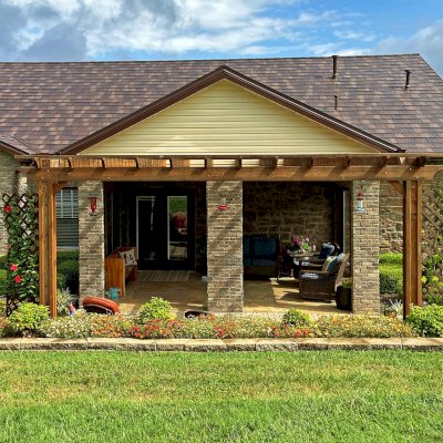 Attached Garden Perglola (Options: 18' x 12', California Redwood, Open Roof with Slats at 12", Rafters at 18", Attached to the Wall by Support Side, 2-Post Anchor Kit for Concrete, No Privacy Panel, No Ceiling Fan Base, Transparent Premium Sealant). Photo Taken 1 Year After Installation. Photo Courtesy of C. Nichols of Clinton, TN.