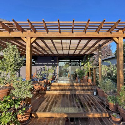 Attached Garden Pergolas (Options: 45'-6" L, One Section is 13' W and the Other Section is 15', Attached to Wall by Rafters Side, California Redwood, 1 Ceiling Fan Base, No Electrical Wiring Trim, Open Roof with Slats at 6", No Decorative Trims on Posts, 5-Post Anchor Kit for High-Wind, Transparent Premium Sealant). Photo Courtesy of D. Herman of Livermore, California.