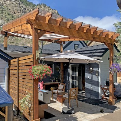 Attached Garden Perglola (Options: 16' x 16', California Redwood, Open Roof with Slats at 18", Rafters at 18", Attached to Existing Posts, with Transparent Rain Guard, 2-Post Anchor Kit for Concrete, No Privacy Panel, 1 Ceiling Fan Base, Transparent Premium Sealant). Photo Courtesy of D. Martin of Georgetown, CO.