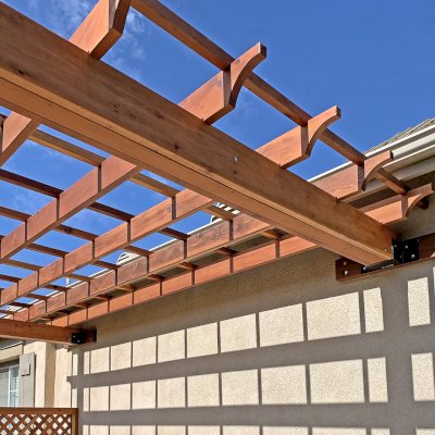 Attached Garden Perglola (Options: 12'-6" x 16', California Redwood, Open Roof with Slats at 18", Rafters at 18", Attached to the Wall by Rafter Side, 2-Post Anchor Kit for Concrete, 1 Lattice Privacy Panel, No Ceiling Fan Base, Transparent Premium Sealant). Photo Courtesy of S. Abbasi of Newbury Park, CA.