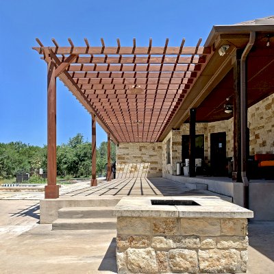 Custom Attached Garden Pergola (Options: 53' x 12', California Redwood, Open Roof with Slats at 12", Rafters at 18", 3-Post Anchor Kit for Concrete, 3 Ceiling Fan Bases, Coffee-Stain Premium Sealant). Ledger Board Attached to Wood House Fascia on 53' Side, and Steel Plate Used to Attach Dual Supports to Masonry House Wall. Photo Courtesy of S. Slawson of Buda, Texas.
