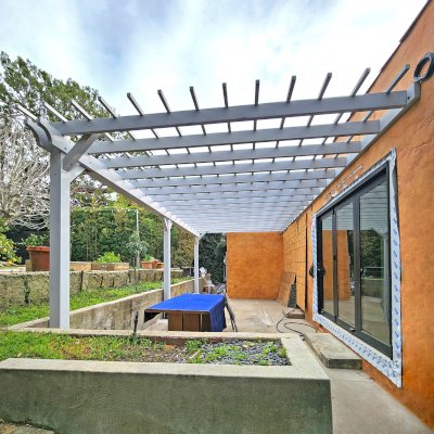 Attached Garden Pergola (Options: 27' L x 14'-4'' W, Attached to Wall by Rafters Side, Mosaic Douglas-fir, Electrical Wiring Trim for 1 Post, Post Anchor Kit for Concrete, Open Roof with Slats at 12", Rafters at 18", No Post Decorative Trims, Gray Oil-Based Primer). Photo Courtesy of V. Spataro of Los Angeles, CA.