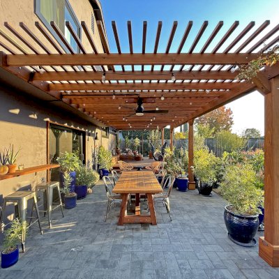 Attached Garden Pergolas (Options: 45'-6" L, One Section is 13' W and the Other Section is 15', Attached to Wall by Rafters Side, California Redwood, 1 Ceiling Fan Base, No Electrical Wiring Trim, Open Roof with Slats at 6", No Decorative Trims on Posts, 5-Post Anchor Kit for High-Wind, Transparent Premium Sealant). Photo Courtesy of D. Herman of Livermore, California.
