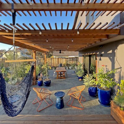 Attached Garden Pergolas (Options: 45'-6" L, One Section is 13' W and the Other Section is 15', Attached to Wall by Rafters Side, California Redwood, 1 Ceiling Fan Base, No Electrical Wiring Trim, Open Roof with Slats at 6", No Decorative Trims on Posts, 5-Post Anchor Kit for High-Wind, Transparent Premium Sealant). Photo Courtesy of D. Herman of Livermore, California.