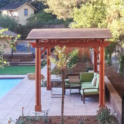 Backyard Pavilion Kits (Options: 10' x 18', California Redwood, No Electrical Wiring Trim Kit, 4-Post Anchor Kit for Concrete, No Ceiling Fan Base, No Privacy Panels, No Curtain Rods, 8.5 ft Post Height, Transparent Premium Sealant). Photo Courtesy of Susan Peters of Novato, CA.