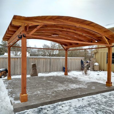 Backyard Pavilion Kits (Options: 15' L x 18' Arc W, California Redwood, 2 Post Electrical Wiring Trims, 4-Post Anchor Kit for Concrete, 1 Ceiling Fan Base, No Privacy Panels, 4 Curtain Rods, 9 ft Post Height, Transparent Premium Sealant). Photo Courtesy of M. McDonald of Lake Barrington, Illinois.