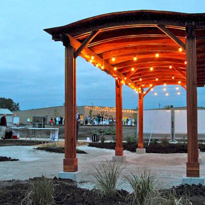 Backyard Pavilion Kits (Options: 30' L x 10' Arc W, California Redwood, No Electrical Wiring Trim, 4-Post Anchor Kit for High-Wind, No Ceiling Fan Base, No Privacy Panels, No Curtain Rods, 9 ft Post Height, Transparent Premium Sealant). Photo Courtesy of Sara Wilson of Ankeny, Iowa.