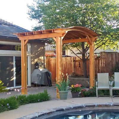 Backyard Pavilion Kits (Options: 12' L x 10' Arc W, Douglas-fir, 1 Post Electrical Wiring Trim, 4-Post Anchor Kit for Concrete, Add Ceiling Fan Base, No Privacy Panels, No Curtain Rods, 9 ft Post Height, Transparent Premium Sealant). Photo Courtesy of R. Short of Roseville, CA.
