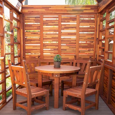 Catalina Island Pergola (Options: 8' x 8', Mosaic Redwood, 8' Post Height, Transparent Premium Sealant). Photo Also Shows a Round Patio Table with Segovia Chairs.