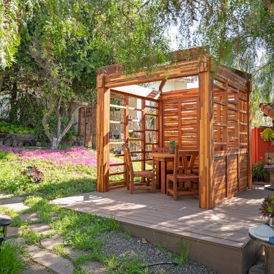 Catalina Island Pergola (Options: 8' x 8', Mosaic Redwood, 8' Post Height, Transparent Premium Sealant). Photo Also Shows a Round Patio Table with Segovia Chairs.