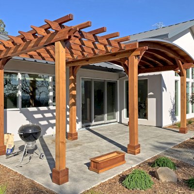 Custom Wood Pavilion Kit with Attached Custom Garden Pergola (Options: 11' L x 16' Arc W [Garden Pergola is 11' L x 8' W], California Redwood, No Post Electrical Wiring Trim, 6-Post Anchor Kit for Concrete, No Ceiling Fan Bases, No Privacy Panels, No Curtain Rods, 10 ft Post Height, Transparent Premium Sealant). Photo Courtesy of K. Jaraczewski of Larkfield-Wikiup, CA.
