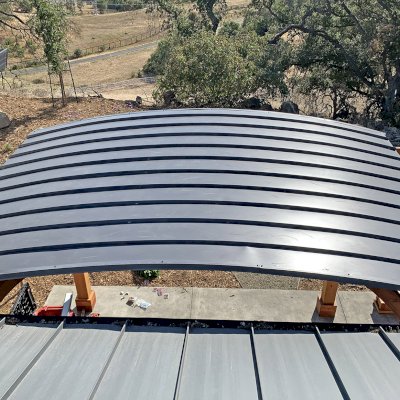 Photo shows a metal roof over an arched pavilion. 