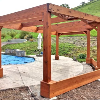 Custom Wooden Pergola (Options: 20' x 12', Mature Redwood, Posts Anchor Kit for High-Wind, Transparent Premium Sealant). Photo Courtesy of D. Ruprecht of Hollister, CA.
