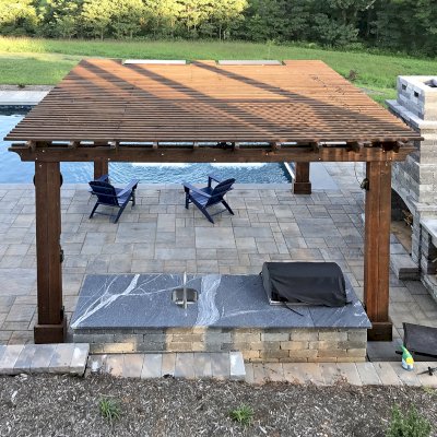 Custom Garden Pergola (Options: 16' L x 16' W, California Redwood, 4-Post Anchor Kit for Concrete, Cherry Stain Premium Sealant). Plumbing was built into the timbers to create a waterfall. Photo Courtesy of D. Hogan of Charlottesville, Virginia.