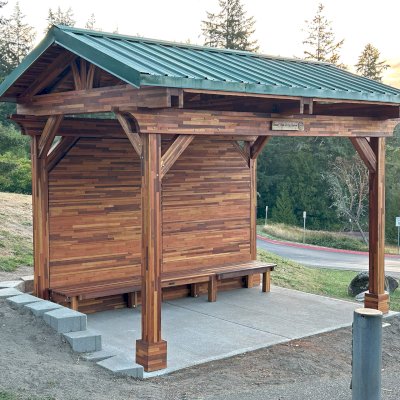 Custom Del Norte Pavilion - Bus Shelter (Options: 14' L x 10' W, Mosaic Redwood, 1 Wall Privacy Panel, Post Anchor Kit for High Wind, 9' H Posts, No Ceiling Fan Base, No Electrical Wiring Trims, No Curtain Rod, Transparent Premium Sealant). Structure Installed at Sehmel Homestead Park in 10123 78th Ave NW, Gig Harbor, WA 98332. , 