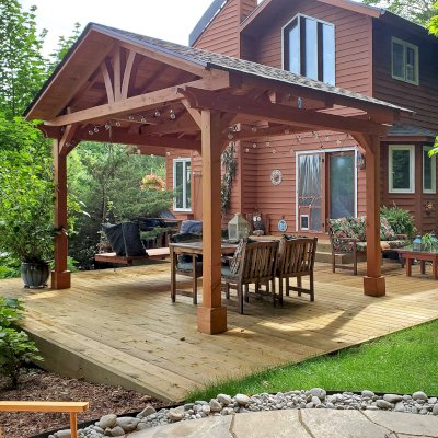 Del Norte Outdoor Kitchen Pavilion (Options: 14' L x 12' W, Douglas-fir, No Privacy Panel, Post Anchor Kit for High Wind, 10' H Posts, No Ceiling Fan Base, No Curtain Rod, Transparent Premium Sealant) with a 6' Jhoola Day Bed Swing. Photo Courtesy of M. Jossens of Traverse City, MI.