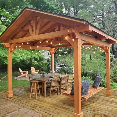 Del Norte Outdoor Kitchen Pavilion (Options: 14' L x 12' W, Douglas-fir, No Privacy Panel, Post Anchor Kit for High Wind, 10' H Posts, No Ceiling Fan Base, No Curtain Rod, Transparent Premium Sealant) with a 6' Jhoola Day Bed Swing. Photo Courtesy of M. Jossens of Traverse City, MI.