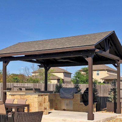 Del Norte Outdoor Kitchen Pavilion (Options: 20' L x 16' W, Mosaic Redwood, 4-Post Anchor Kit for Concrete, 10.5' H Posts, 1 Ceiling Fan Base, 2 Fascia Boards, Custom Sealant [Cordovan Brown Solid Color]). Photo Courtesy of S. Oster of Round Rock, Texas.