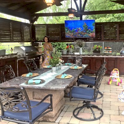 Del Norte Outdoor Kitchen Pavilion (Options: 20' L x 18' W, Mature Redwood, 4-Post Kit for High-Wind, 2 Ceiling Fan Bases, 2 Electrical Wiring Trim Kits, 2 Sets of Louvers on 2 Sides, No Post Decorative Trims, 9' H Posts Wrapped in Stone After Installation, Coffee-Stain Premium Sealant). Photo Courtesy of Shawn and Marilyn Murray of Walden, New York.
