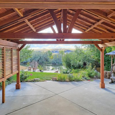 Del Norte Outdoor Kitchen Pavilion (Options: 20' L x 18' W, California Redwood, 1 Louver Privacy Panel Half Height Without Wall, 4-Post Anchor Kit for High-Wind, 9' H Posts, No Ceiling Fan Base, No Fascia Boards, Electrical Wiring Trim Kit for 3 Posts, Transparent Premium Sealant). Photo Courtesy of N. Hodder of Casper, Wyoming.