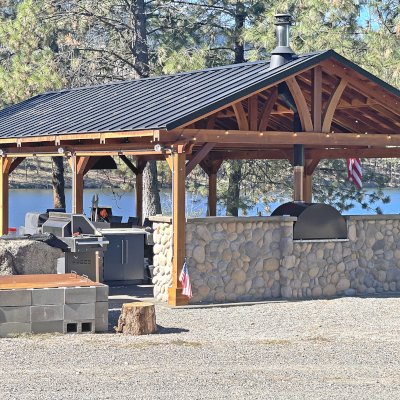 Del Norte Outdoor Kitchen Pavilion (Options: 38.5' L x 18.5' W, California Redwood, No Privacy Panel, Post Anchor Kit for High Wind, 10' H Posts, No Ceiling Fan Base, No Curtain Rod, No Fascia Boards, Transparent Premium Sealant). Photo Courtesy of D. Lemke of Nine Mile Falls, NJ. 