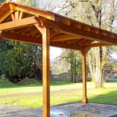 Custom Del Norte Outdoor Kitchen Pavilion (Options: 20' L x 10' W, Douglas-fir, 4-Post Anchor Kit for High-Wind, No Ceiling Fan Base, Transparent Premium Sealant). Larger lumber by custom request. Roofing was still pending when shots taken just after assembly. Photo Courtesy of S. Flanagin of Carnation, WA.